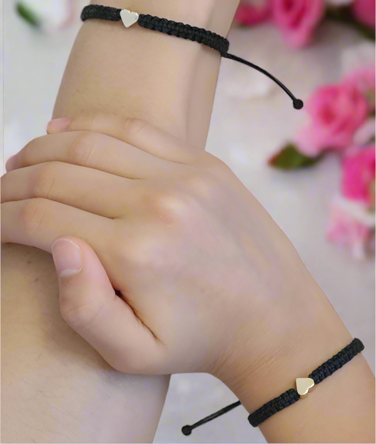Adjustable couples matching bracelet set with a gold heart charm on a black waterproof cord, one 6 inches and the other 6.5 inches.