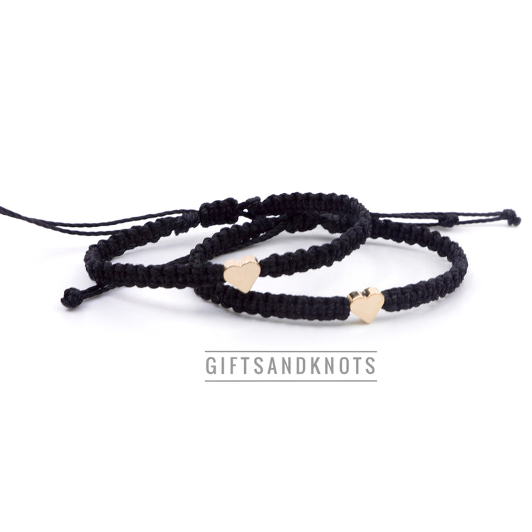 Adjustable couples matching bracelet set with a gold heart charm on a black waterproof cord, one 6 inches and the other 6.5 inches.