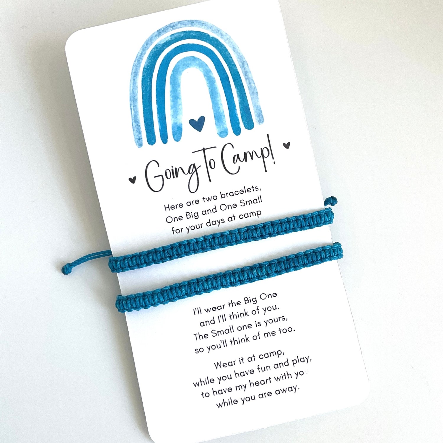 Two turquoise bracelets on a card with text and a rainbow design, on a white background