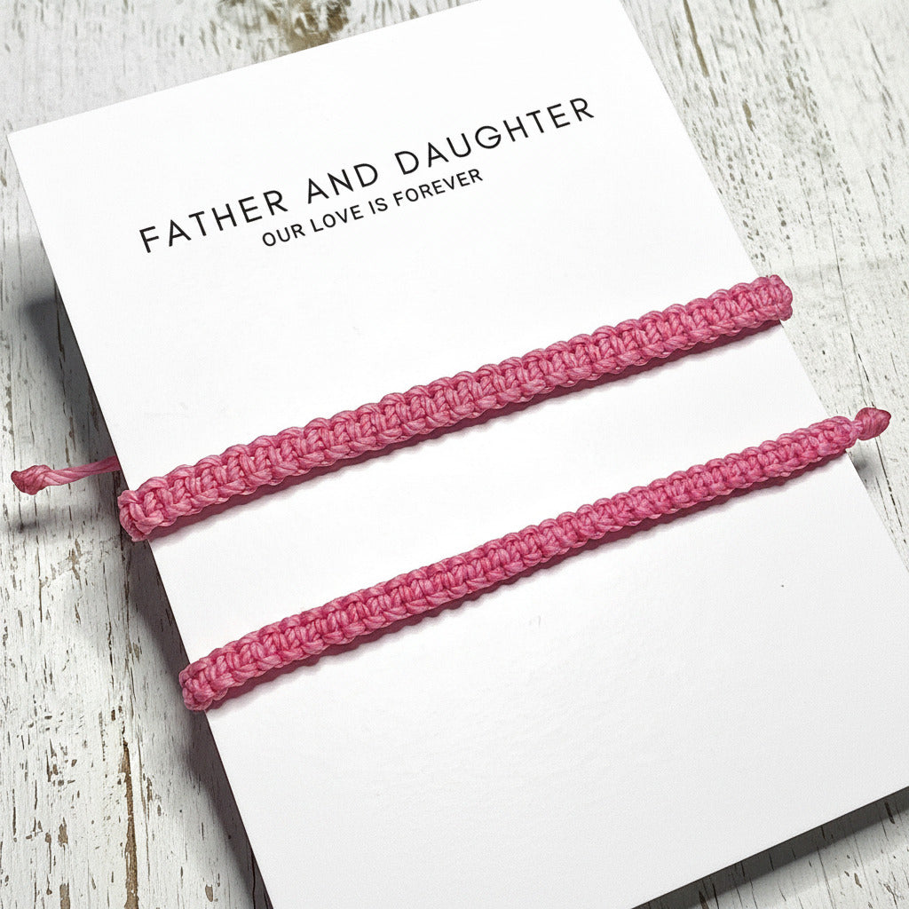 Two pink braided bracelets on a card with 'Father and Daughter Our Love is Forever' .