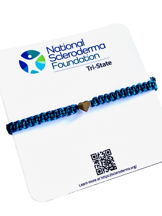 Teal braided bracelet with a silver heart charm on a National Scleroderma Foundation card.